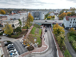 Luftaufnahme eines städtischen Bereich beim Kuhtor mit einer Brücke über eine Straße, mehreren Gebäuden und herbstlich gefärbten Bäumen