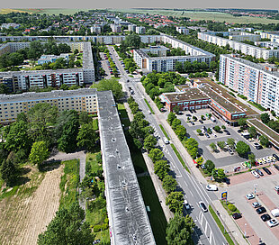Luftaufnahme des Wohngebiets Lichtenhagen mit mehrstöckigen Plattenbauten, Straßen, parkenden Autos und Grünflächen