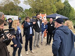 Gruppe von Menschen, die im Freien stehen und sich unterhalten.