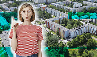 Frau in rot-weiß gestreiftem T-Shirt zeigt mit erhobenem Zeigefinger vor einer Luftaufnahme von Wohnblocks in Lichtenhagen
