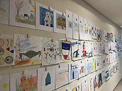 Viele bunte kleine Bilder an einer Wand. 