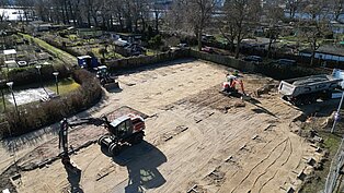 Luftaufnahme der Bauarbeiten der neuen Stellplatzfläche der Kleingartenanlage Fährhufe in Gehlsdorf mit Bagger und LKW