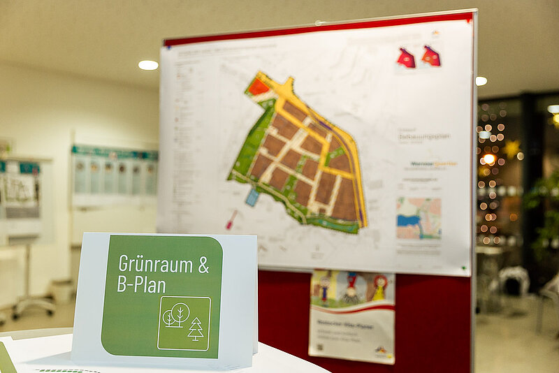 Plan mit farbigen Markierungen auf einem weißen Blatt, befestigt an einer roten Wand