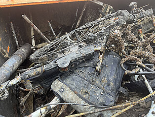 verrosteter Metallschrott mit Drahtgeflecht und verschiedenen Rohren in einem Container