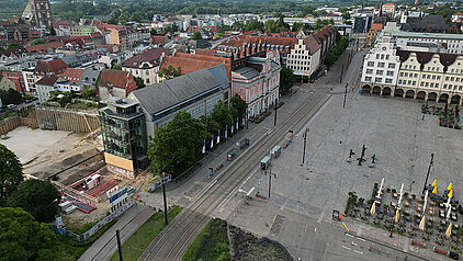 Luftaufnahme des großen Platzes Neuer Markt mit historischen Gebäuden, dem Rathaus, der Baustelle links und einer Straßenbahnlinie in der Mitte