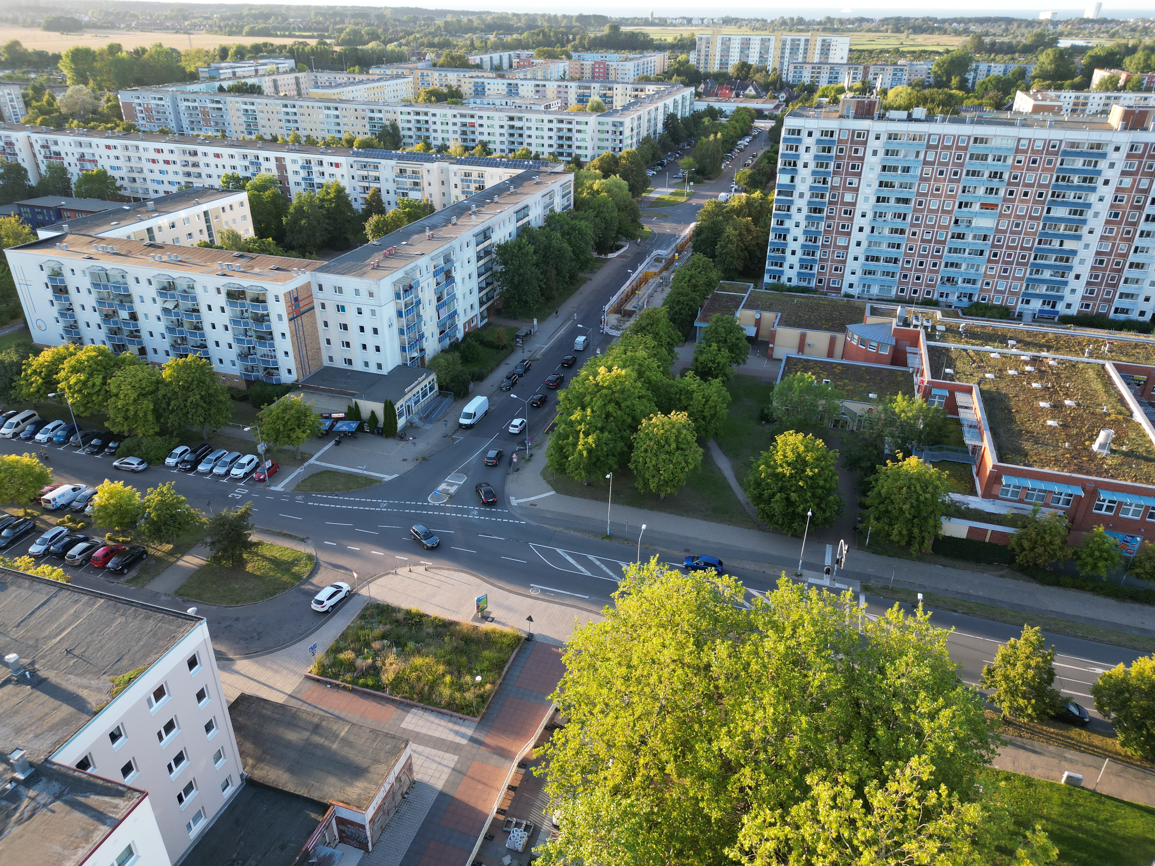 Luftaufnahme von Lichtenhagen mit Blick auf die Güstrower und Parchimer Straße  mit mehrstöckigen Plattenbauten, Straßen mit parkenden Autos und vielen Bäumen