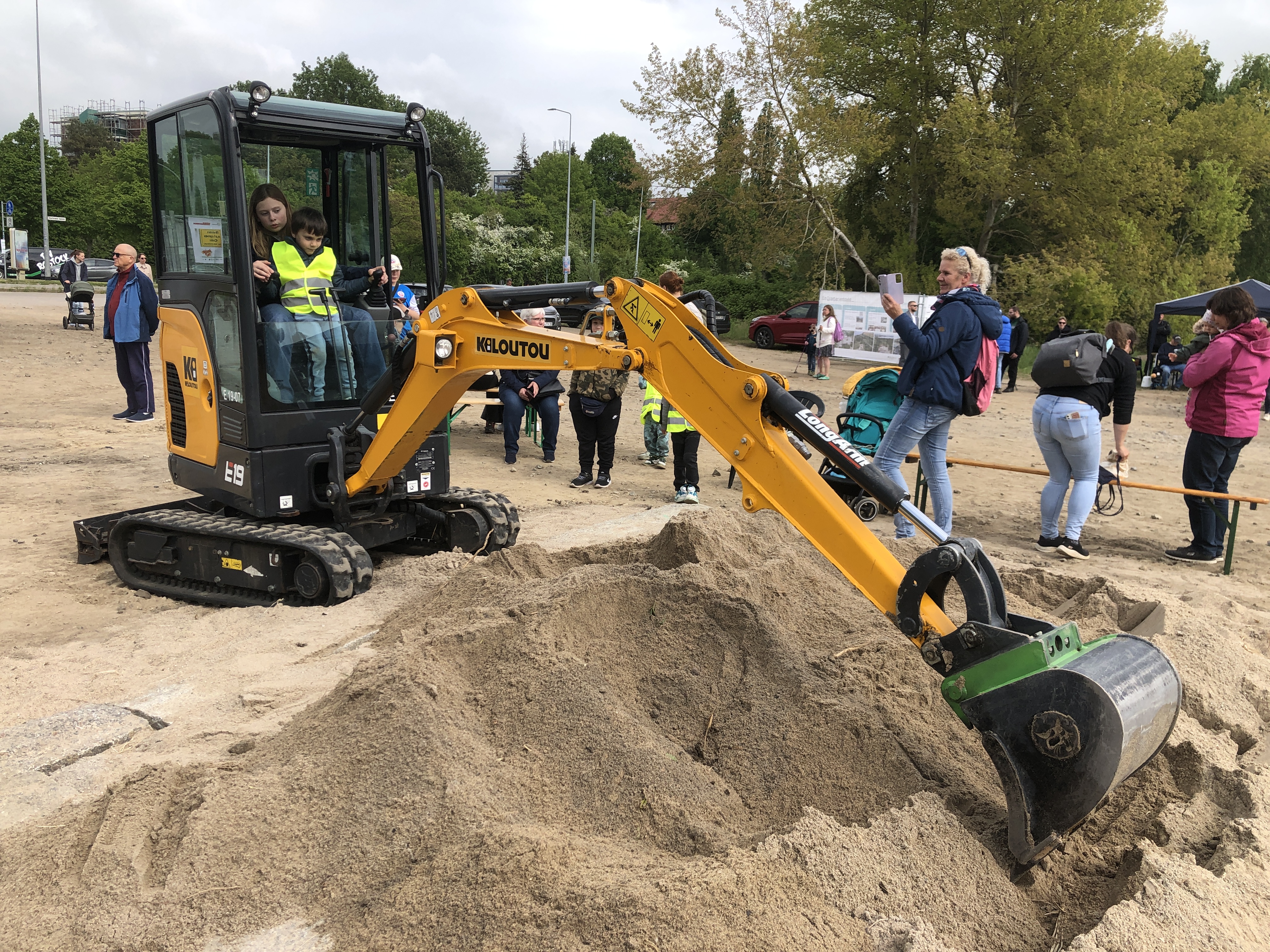 Ein gelber Bagger bei Sandarbeiten.